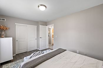 A bedroom with a large bed and a closet